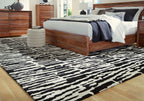Black-and-white abstract striped area rug laid flat on the floor