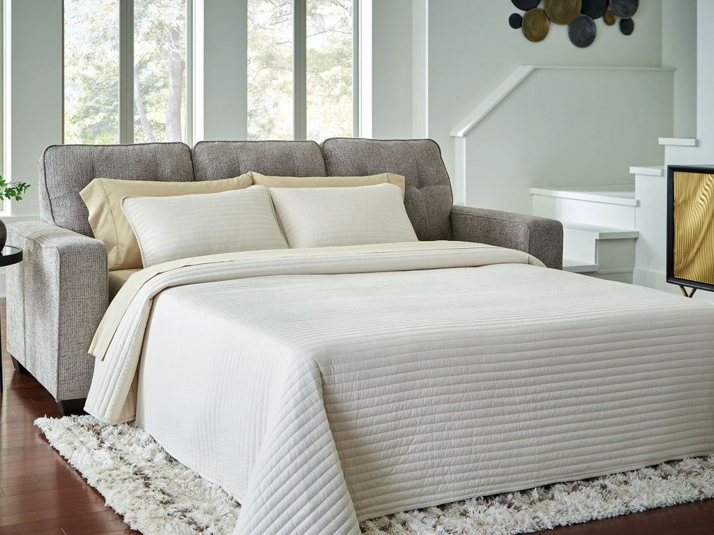 Queen sofa sleeper in gray with beige bedding extended into a bed