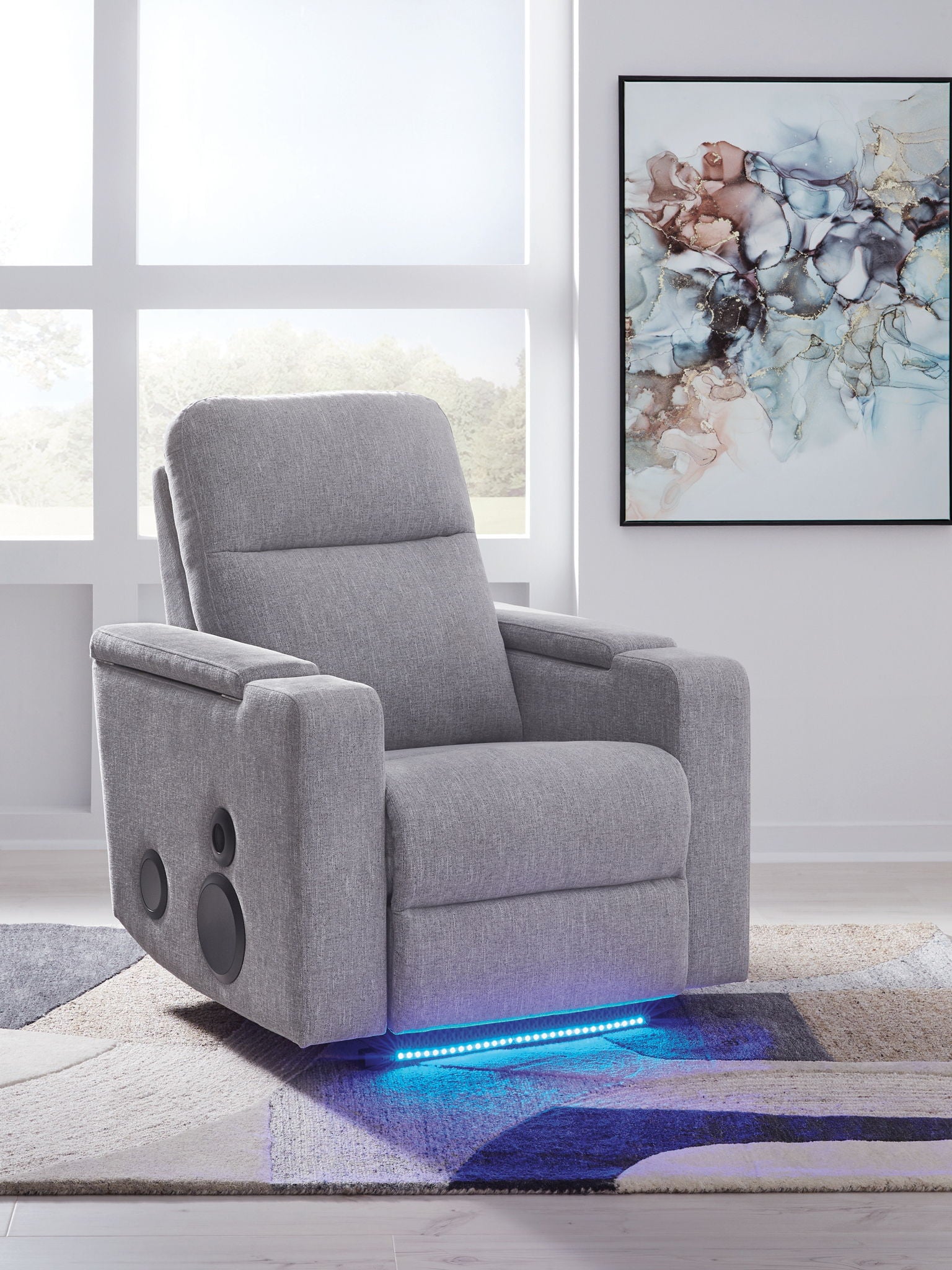 Pewter gray power recliner with armrest speaker cutouts and built-in footrest