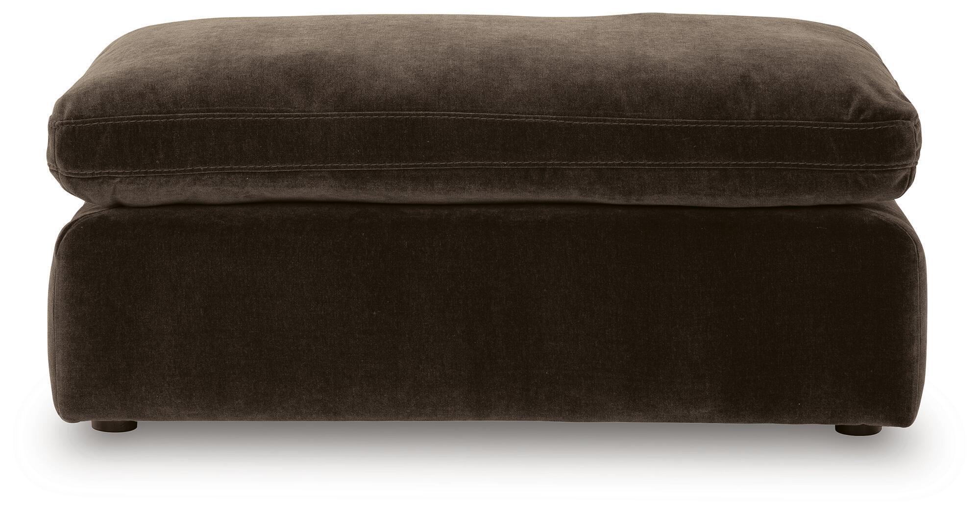 Dark brown upholstered ottoman with padded top cushion and short legs