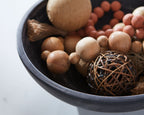 Meadie bowl filled with assorted wooden spheres and rope ball