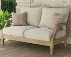 Beige loveseat with cushion, wood frame, and two patterned throw pillows