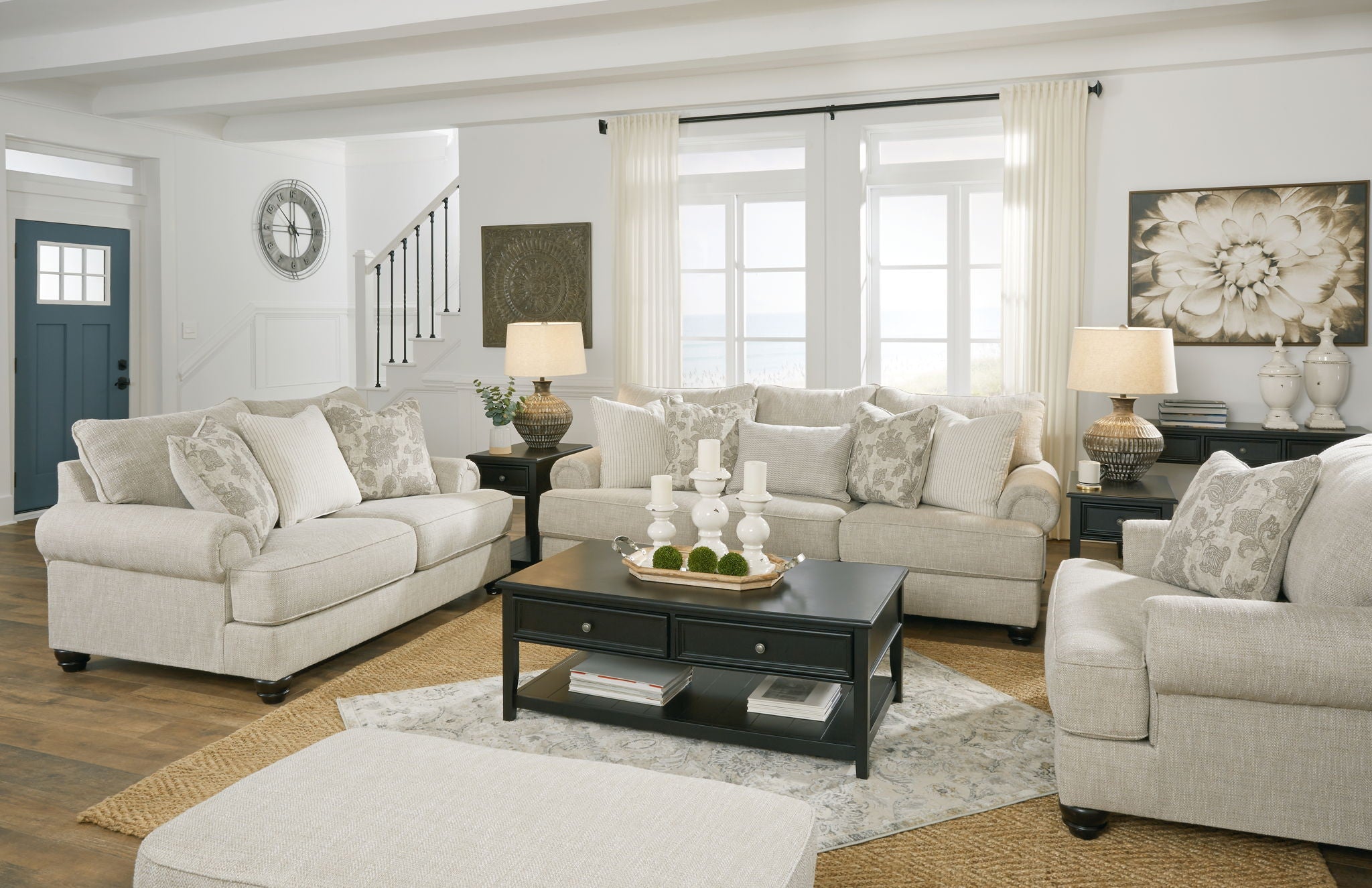 Light gray living room set with sofa and loveseat, ottoman, and patterned pillows