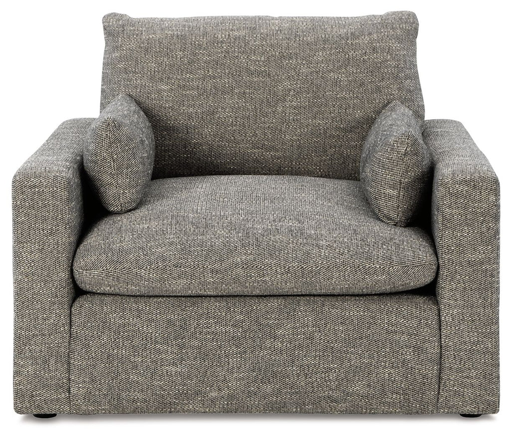 Gray upholstered single chair with two back pillows and padded armrests
