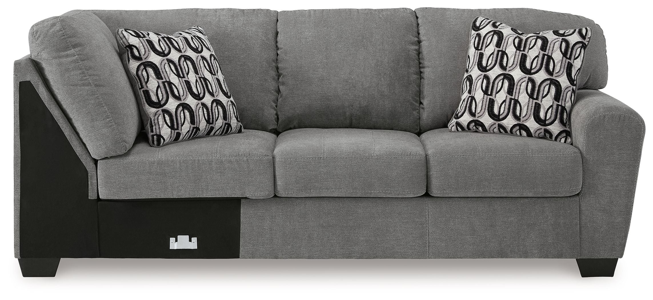 Gray fabric corner wedge sofa with three seat cushions, square arms, and patterned pillows