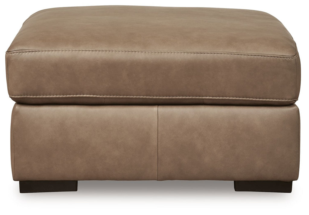 Taupe upholstered ottoman with cushioned top and side seam, black feet
