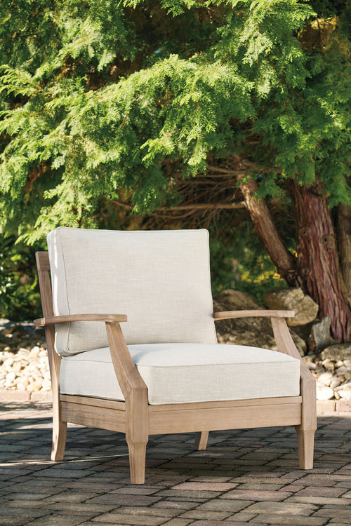 Beige lounge chair with cushion, light wood arms, upholstered backrest and seat.