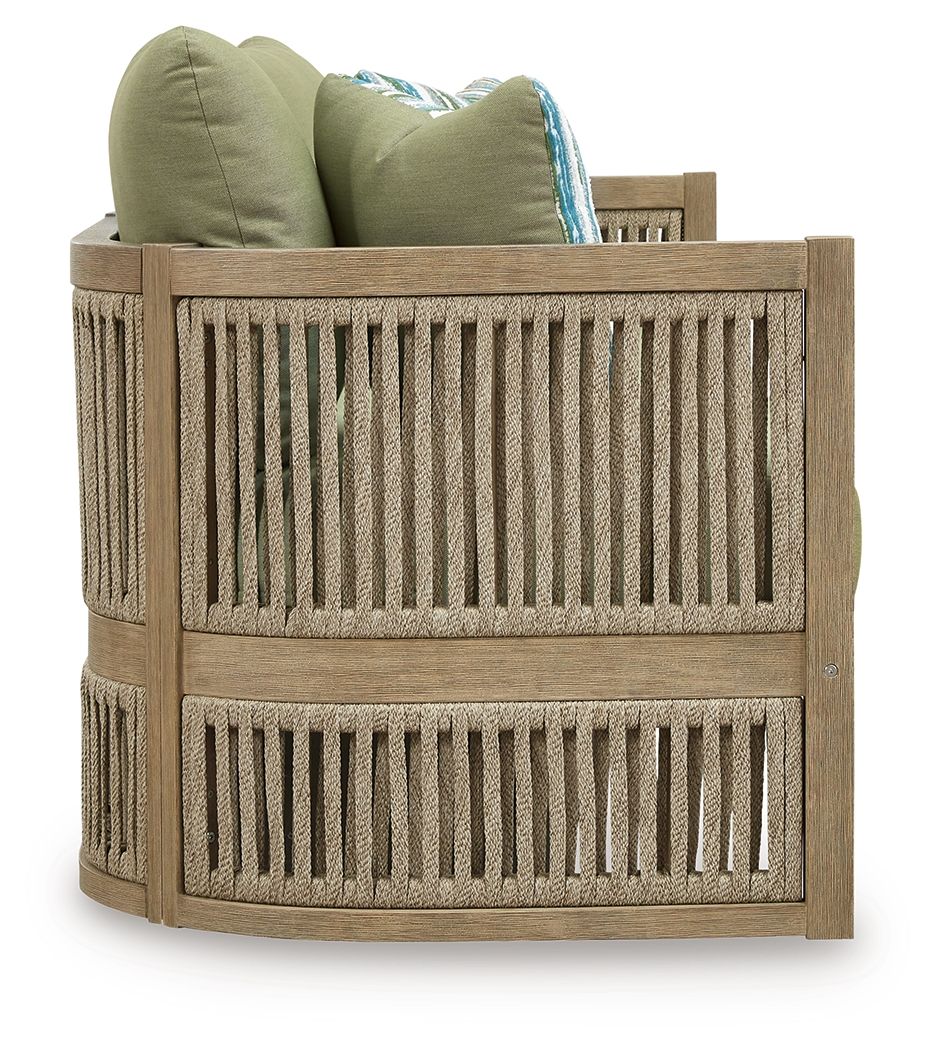 Outdoor sofa backrest with green pillows, beige slatted sides, and striped bolster
