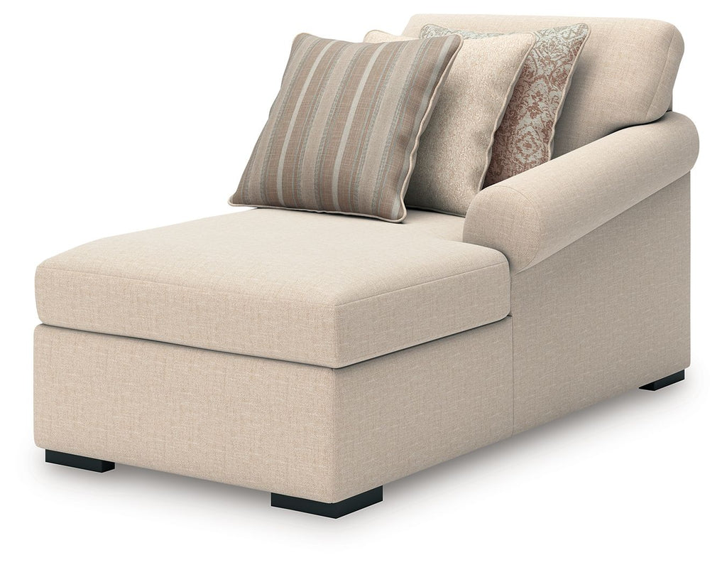 Beige corner chaise lounge with striped and patterned throw pillows, rolled arms