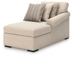Beige corner chaise lounge with striped and patterned throw pillows, rolled arms