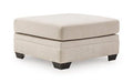 Beige upholstered ottoman with square top and dark angled legs
