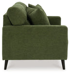 Green loveseat with thick arms and tufted back, shown from the side with three pillows.