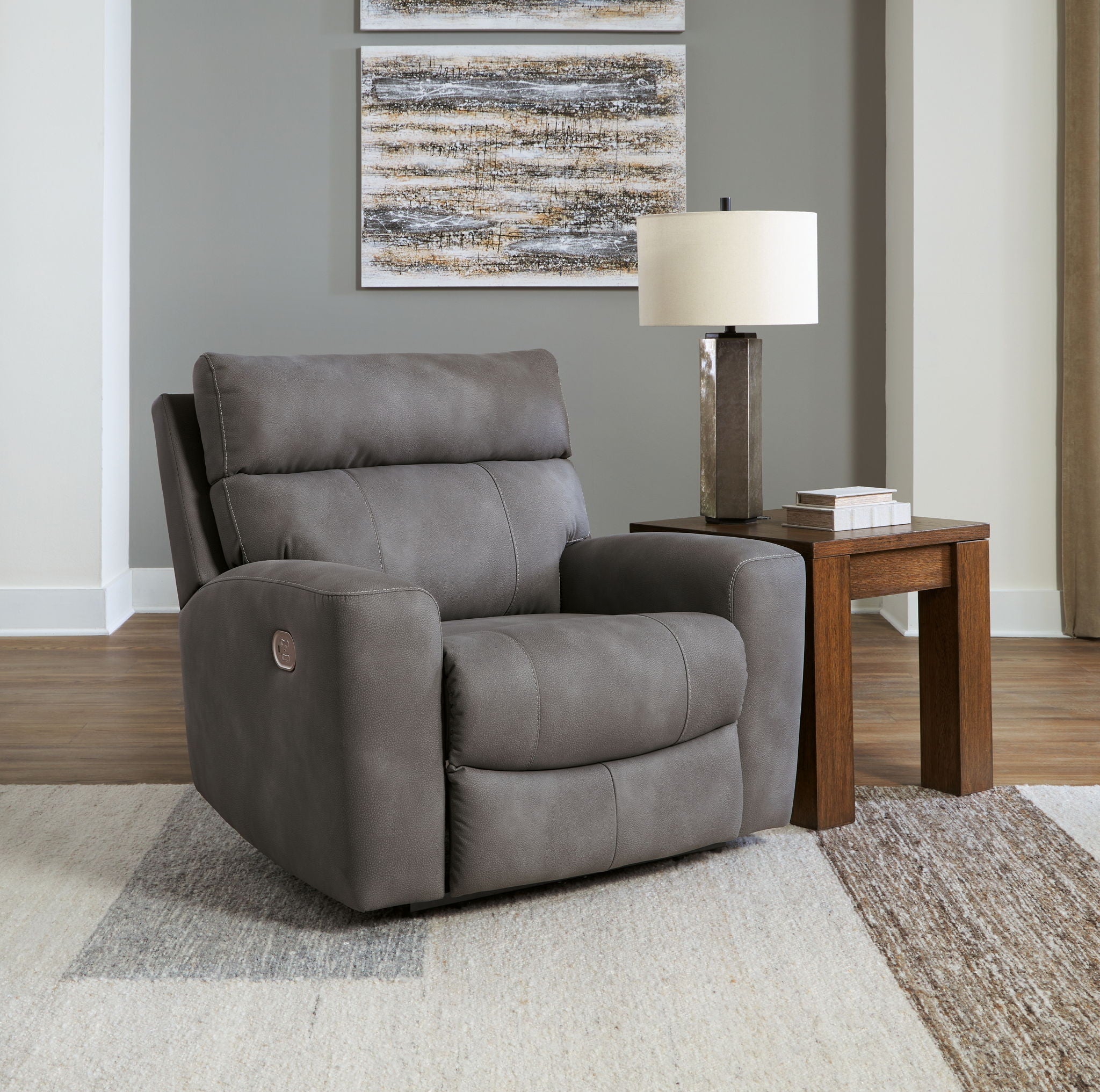 Slate gray recliner with adjustable headrest, shown in living room