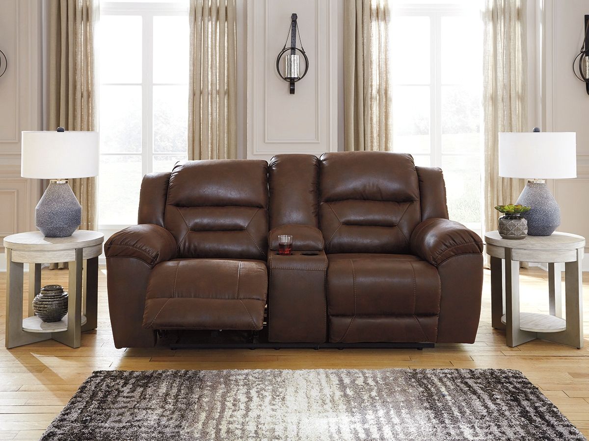 Reclining loveseat in medium-dark brown leather with padded back cushions and recline headrests