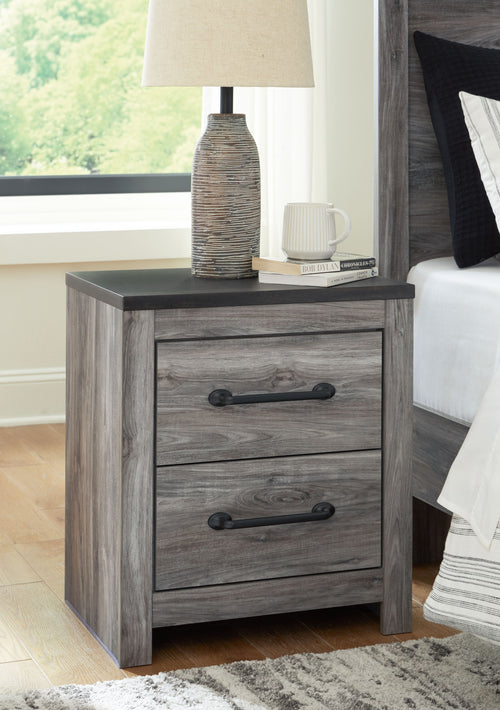 Two-drawer night stand in gray woodgrain with dark pull handles and straight legs.