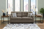Light gray sofa with two seat cushions and two patterned throw pillows