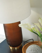 Amber glass table lamp with white drum shade and brass round base