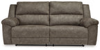 Reclining sofa in dark brown fabric with tufted back cushions and armrests