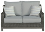 Gray wicker loveseat with two back cushions and two striped throw pillows