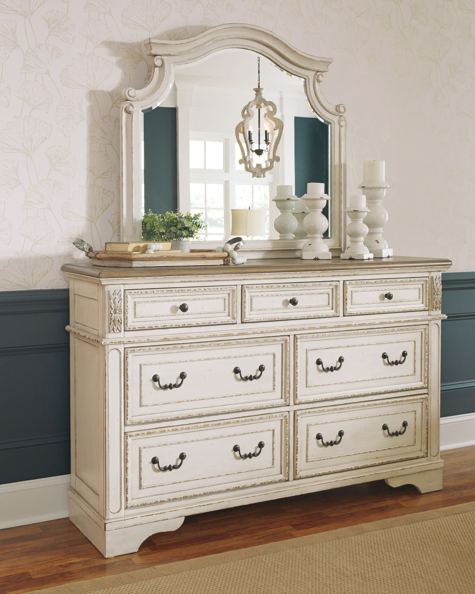 White dresser with mirror and six drawers, ornate detailing and vintage-style drawer pulls.