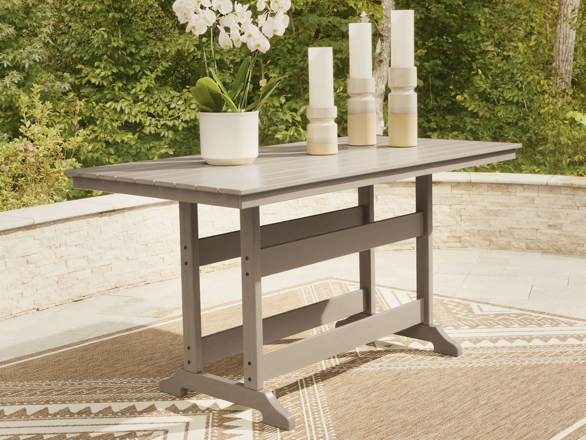 Rectangular counter-height dining table, medium brown wood, slatted surface and lower shelf.