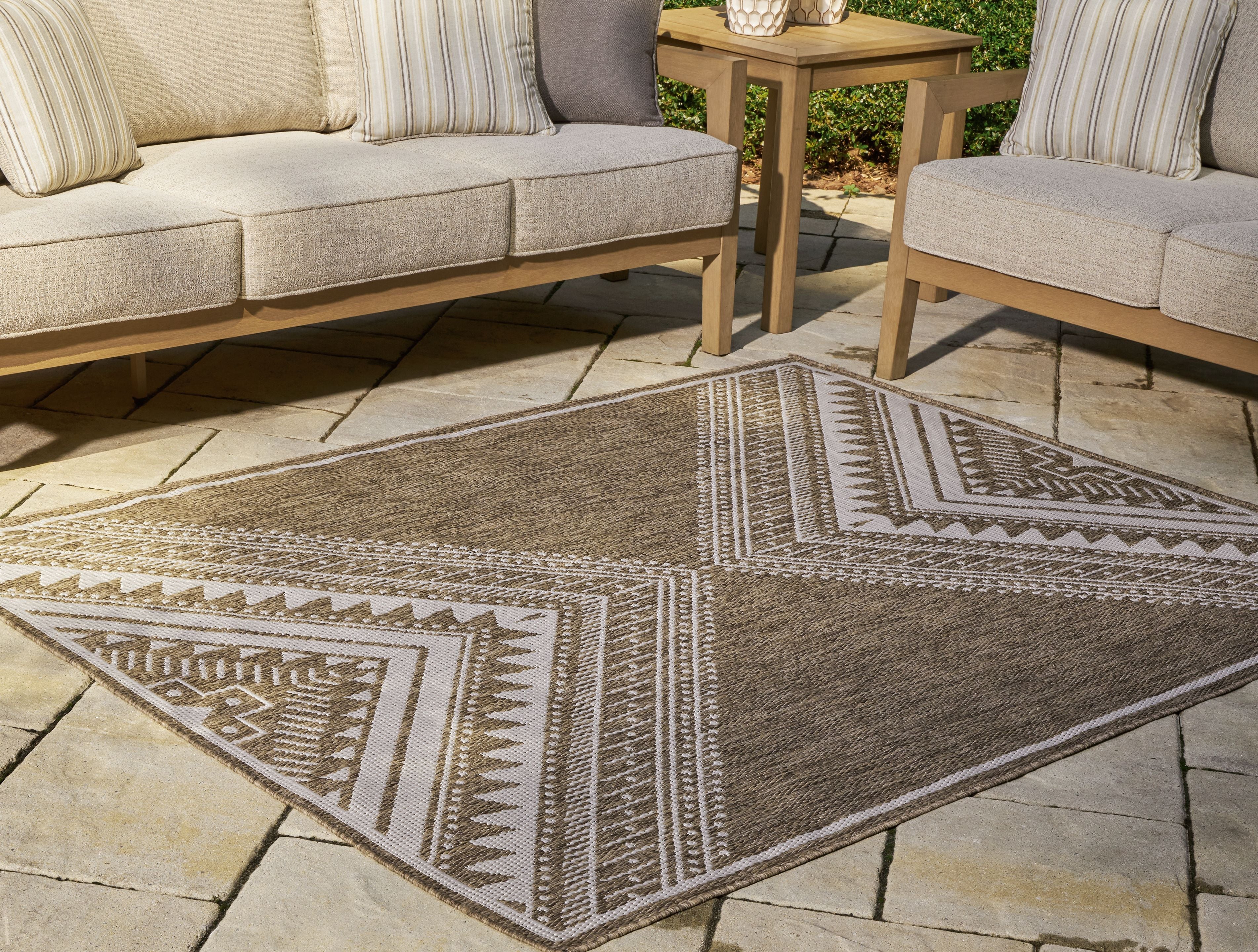 Brown area rug with cream tribal geometric lines, corner edge visible
