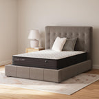 Firm mattress with white quilted top on a gray upholstered bed frame