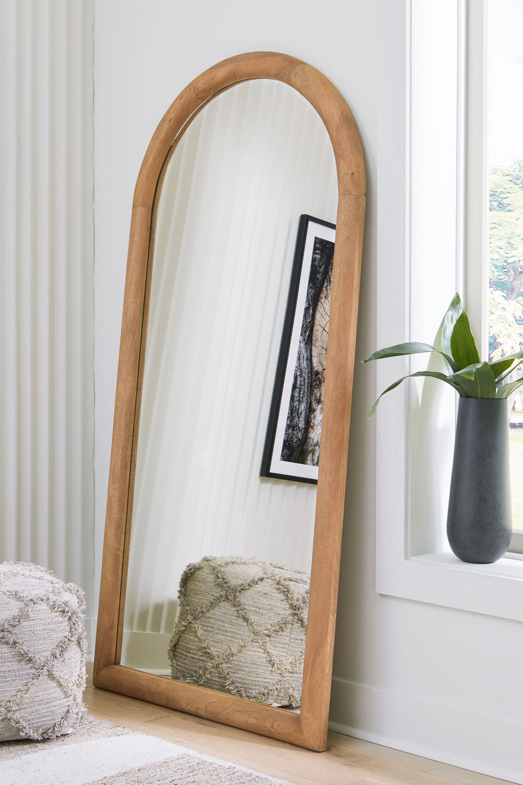 Arched floor mirror with wooden frame and clear reflective glass