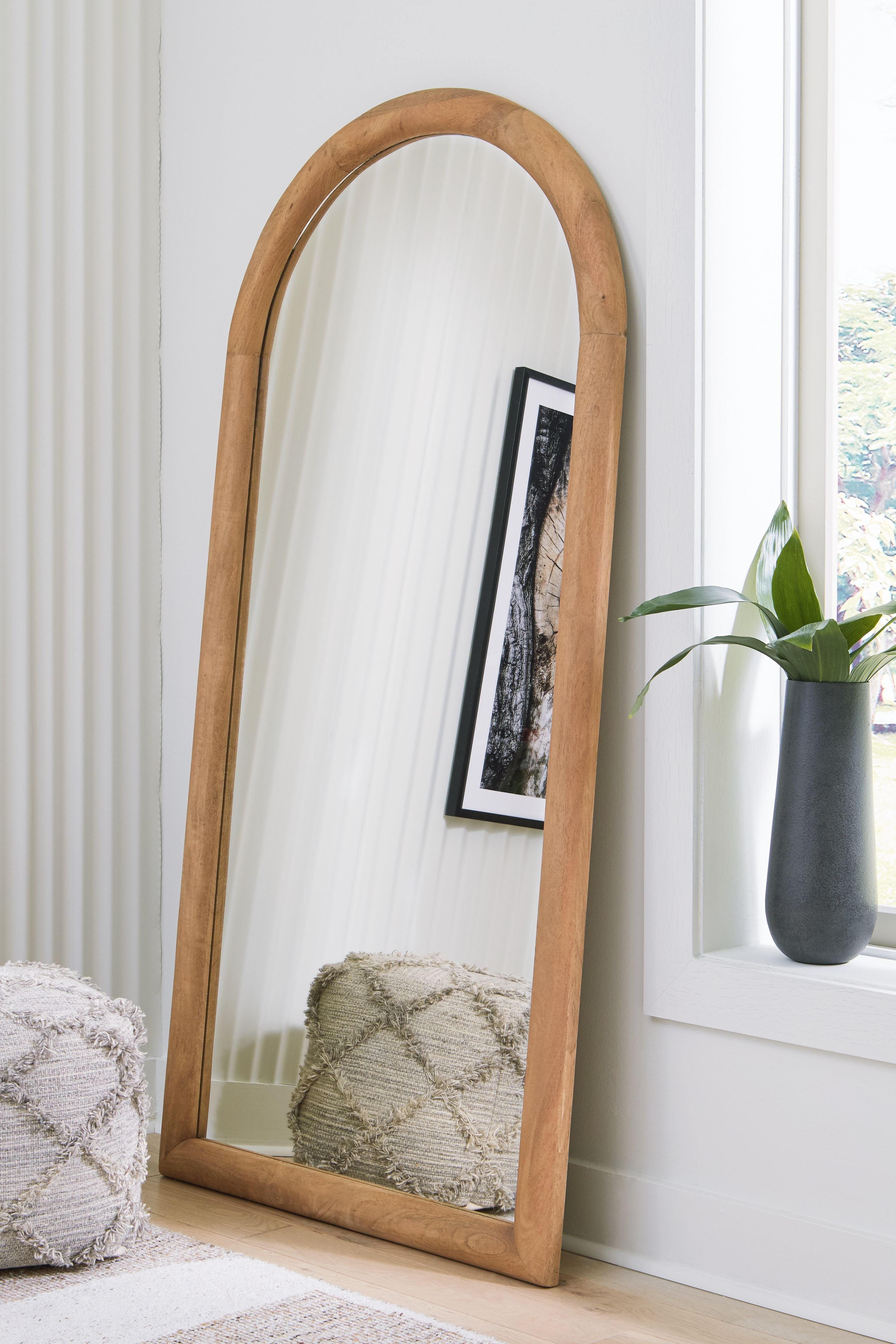 Arched floor mirror with wooden frame and clear reflective glass