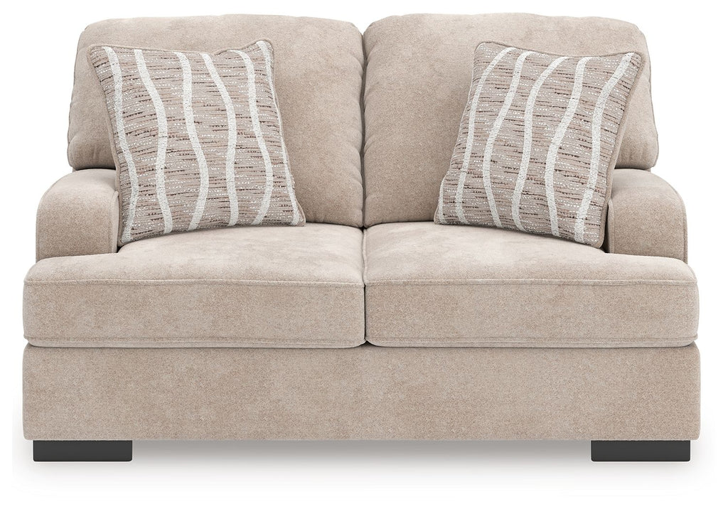 Taupe loveseat with two back cushions and two gray striped pillows, low black legs