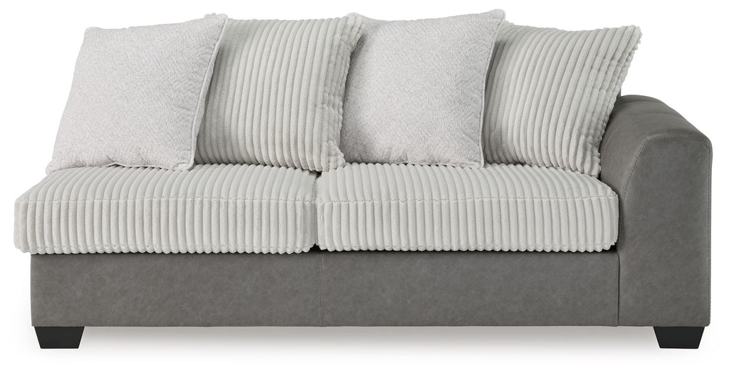 Gray sofa with ribbed cushion back, three throw pillows, and thick side arms