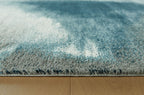 Blue abstract rug close-up of short cut pile with cream distressed swirls