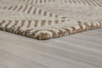 Beige rug corner with short fringe and repeating geometric pattern