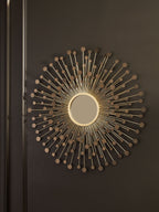 Accent wall mirror with round center mirror and bronze-gold radiating metal rod design