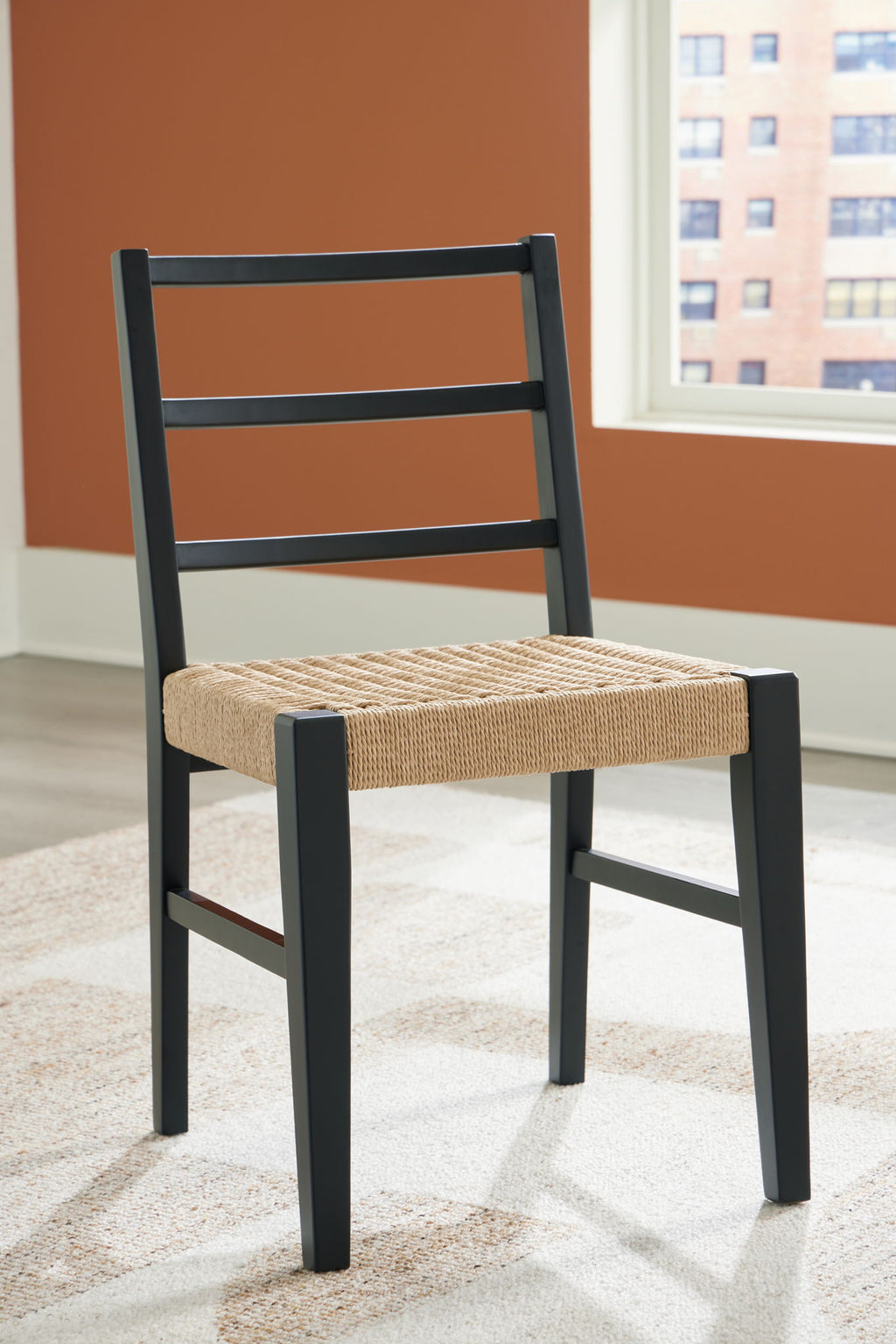 Dining room side chair with black legs and light brown woven seat