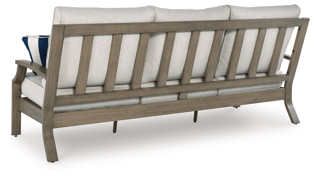 Light gray sofa with dark wood arm and back slats, two blue striped throw pillows