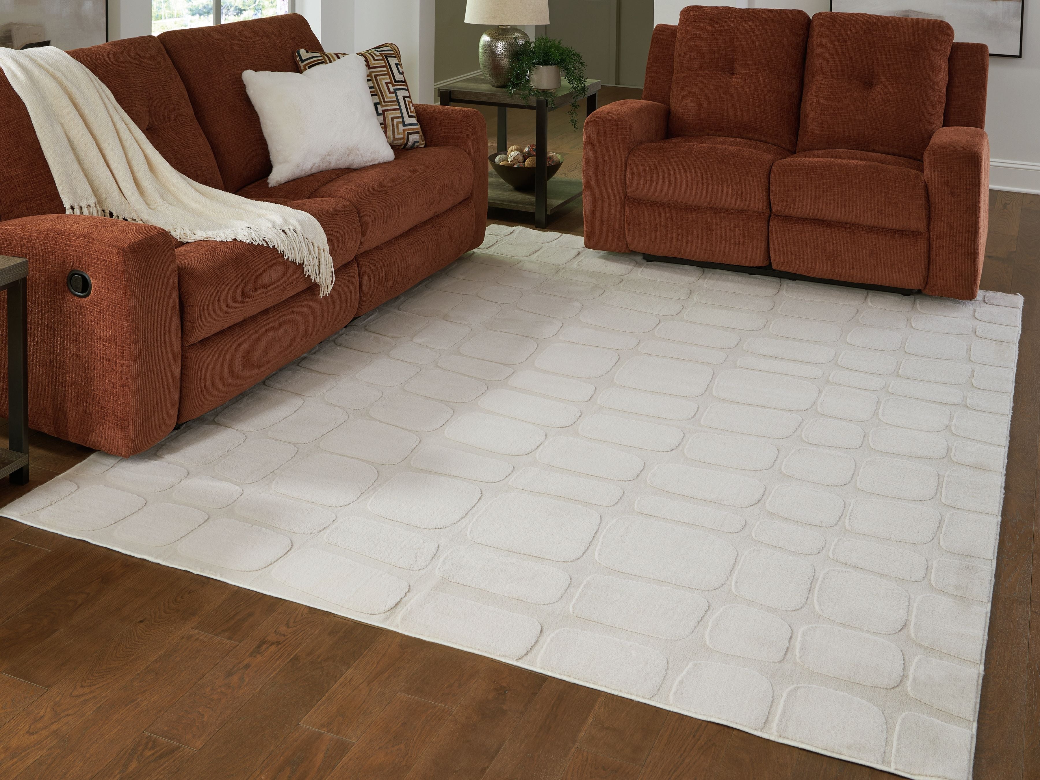 Washable beige rug with embossed stone pattern under living-room seating