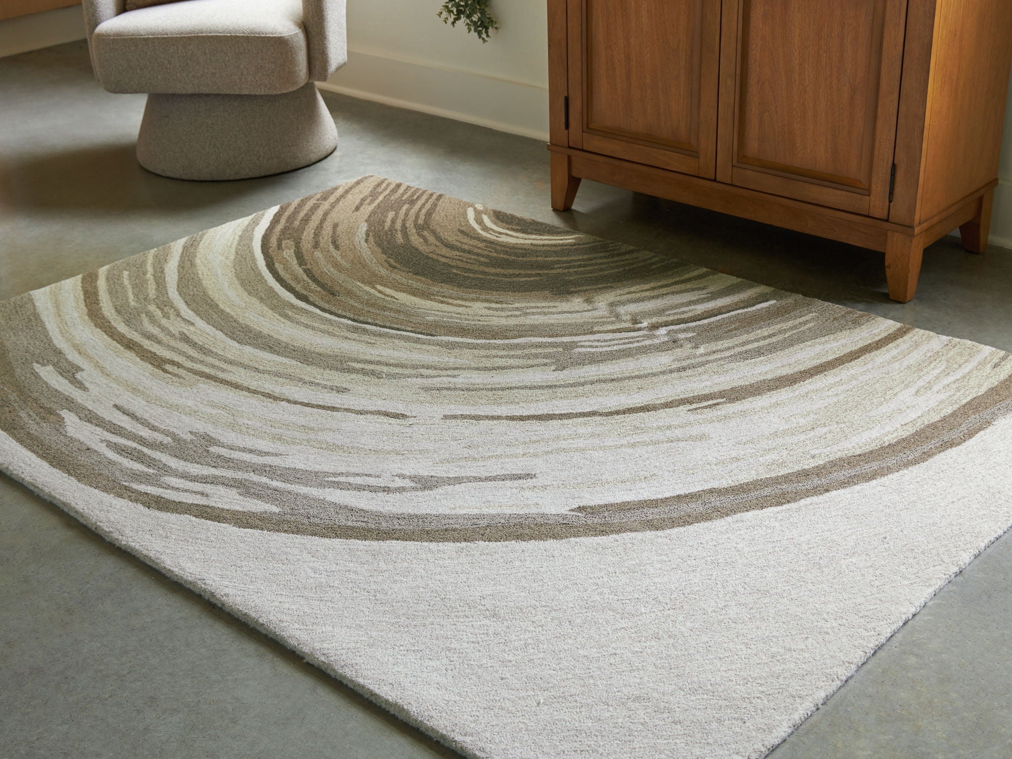 Rug in cream and dark olive with concentric wave stripes, textured low pile
