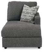 Dark gray corner chaise with tall backrest and patterned throw pillow