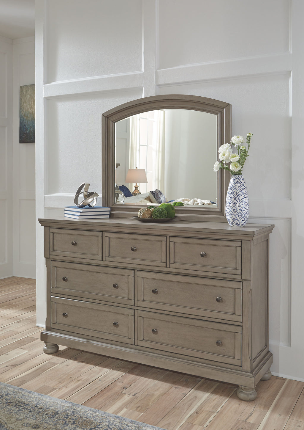 Gray dresser with large mirror and drawers, styled on bedroom wall