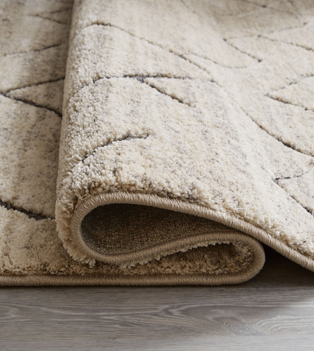 Gray rug edge with short pile and stitched border
