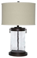 Clear glass table lamp with beige fabric drum shade and bronze base
