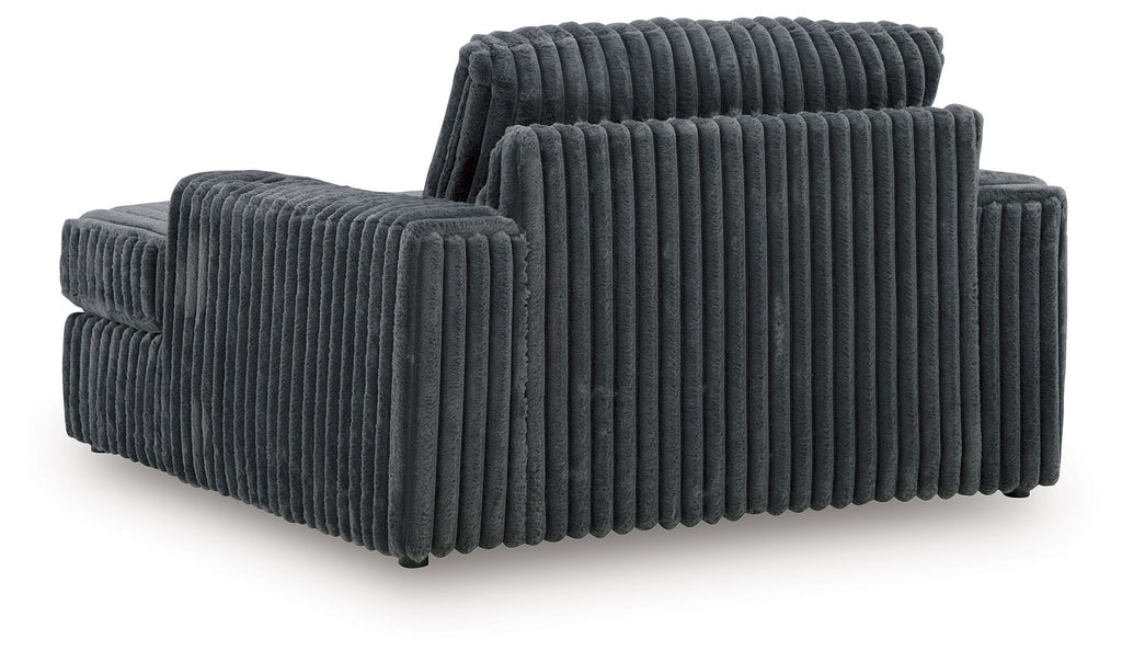 Oversized chaise with ribbed dark gray fabric, broad track arms and raised back cushion.