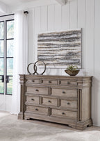 Light gray-brown dresser with nine drawers and round metal knobs.