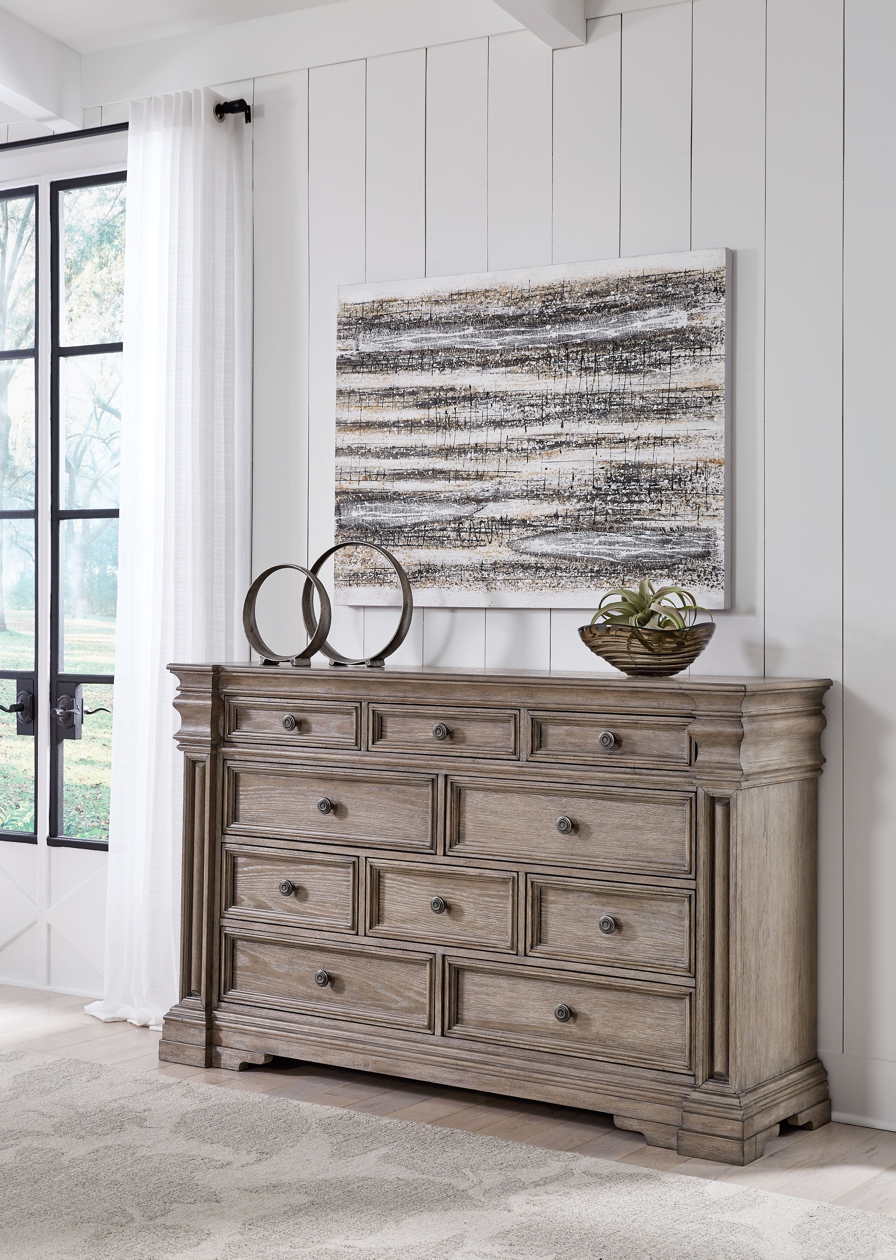 Light gray-brown dresser with nine drawers and round metal knobs.