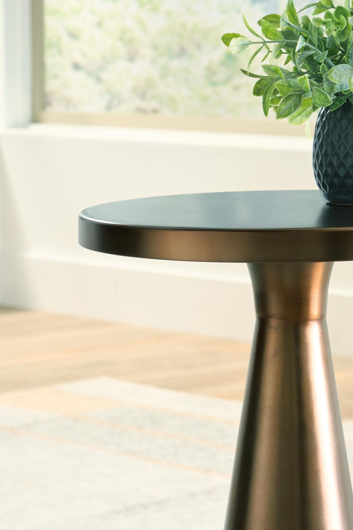 Bronze accent table top edge with round surface and tapered support