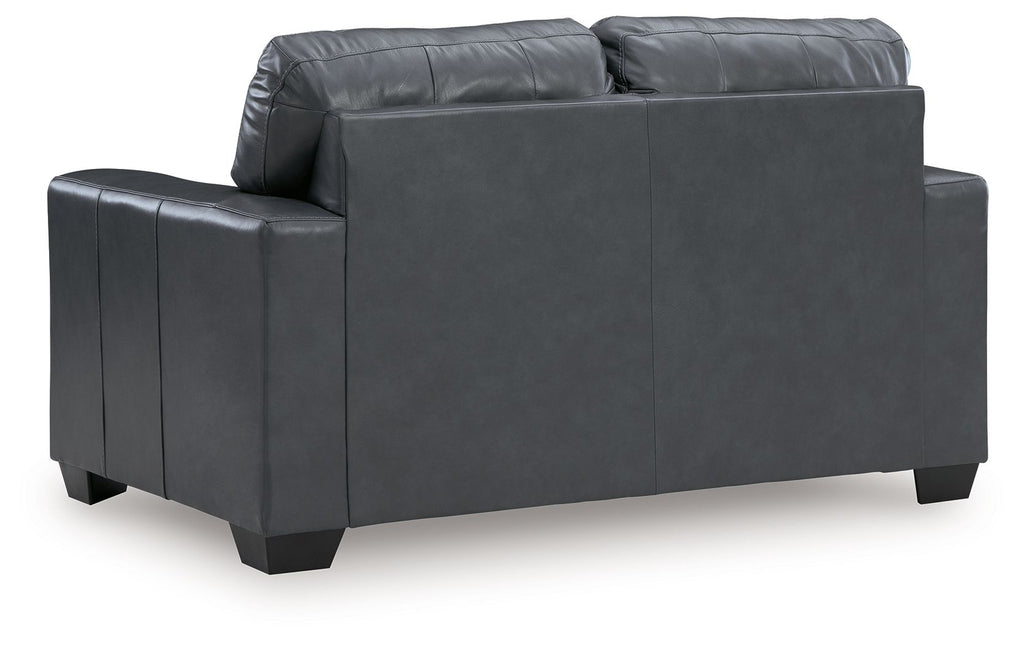 Gray loveseat sofa shown from the side with arm pads and dark square feet