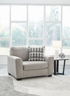 Gray flannel chair and a half with patterned back pillow on rug