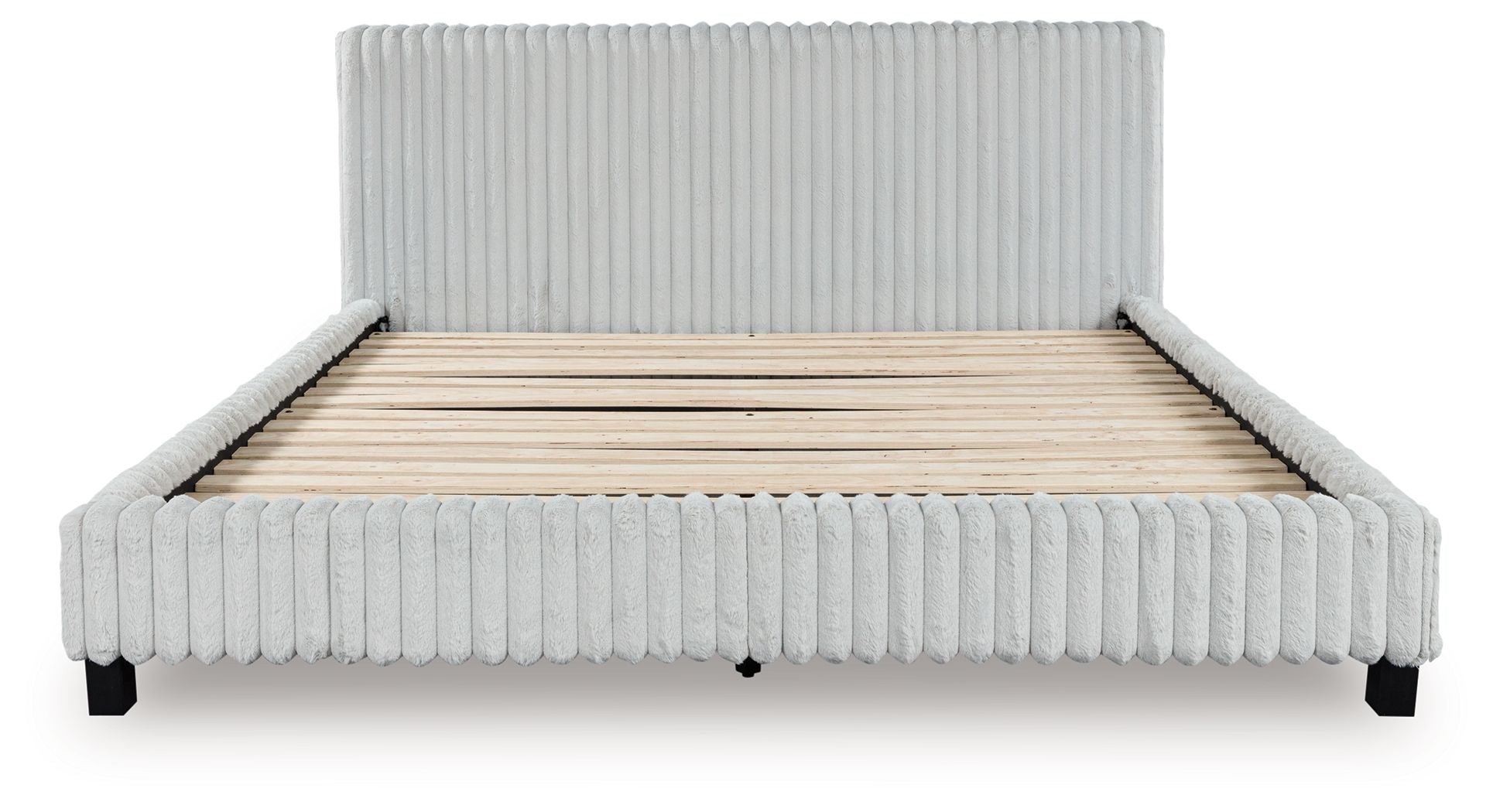 Upholstered bed with light ribbed frame and headboard, uncovered beige mattress base