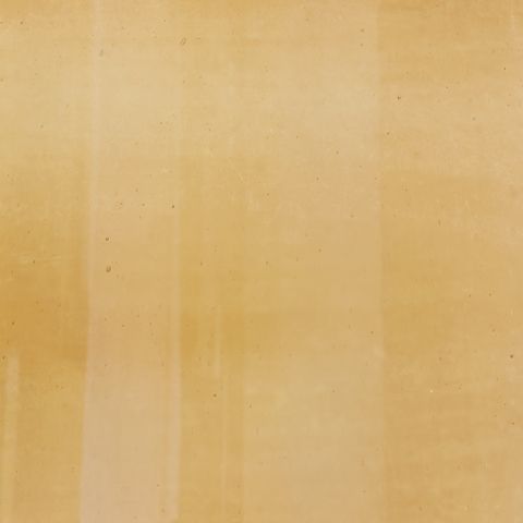 Close-up of amber glass vase surface with mottled speckles